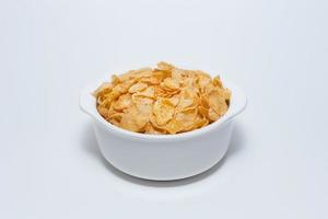 bild närbild cornflakes spannmål frukost i vit skål på vit bakgrund. foto