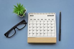 augusti 2023 skrivbordskalender på blå bakgrund. direkt ovanför. foto