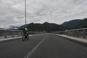 triathlonatlet som cyklar på morgonträning foto