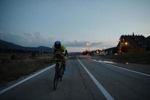 triathlon atlet cyklar på natten foto