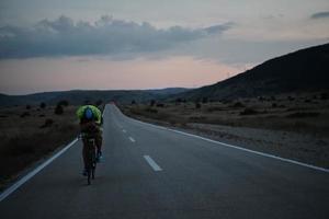 triathlon atlet cyklar på natten foto