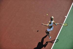 ung kvinna spela tennis utomhus foto