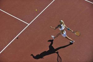 ung kvinna spela tennis utomhus foto