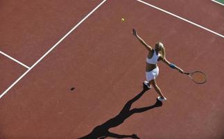 ung kvinna spela tennis utomhus foto