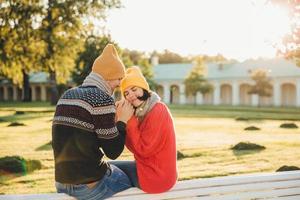 människor, relationer, samhörighet och kärlekskoncept. vacker kvinna sluter ögonen med njutning när hon håller pojkvänners händer, har romantiska relationer, njuter av varje minut av att spendera tillsammans foto