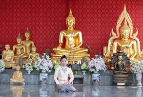 thailändska kvinnor som sitter med händerna i templet foto