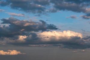 blå himmel bakgrund med kvällen fluffiga lockiga rullande moln. bra blåsigt väder foto