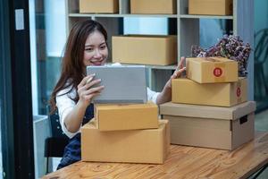 onlineförsäljning kvinna företagsägare ta emot beställningar och leverera produkter med lådor till kunder. online SM affärsidé foto