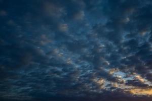 mörkblå himmel bakgrund med små stratus cirrus randiga moln. klarningskväll och bra blåsigt väder foto