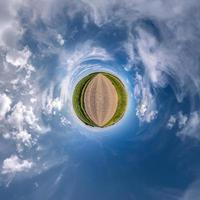 liten planetomvandling av sfäriskt panorama 360 grader. sfärisk abstrakt flygfoto i fält med fantastiska vackra moln. utrymmets krökning. foto