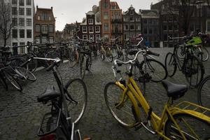 amsterdam, nederländerna, 2015 - cyklar och framsidan av typiska kanalhus i amsterdam foto