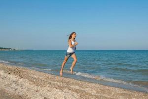ung flicka springer på havet foto
