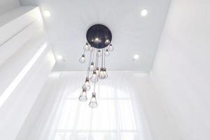 tittar upp på undertak med halogenspotslampor och gipskonstruktion i tomt rum i lägenhet eller hus. sträcktak vit och komplex form. foto