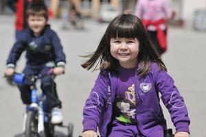 glad barngrupp som lär sig att köra cykel foto