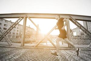 man joggar över bron på solig morgon foto