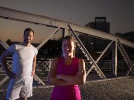 porträtt av par joggar över bron i staden foto