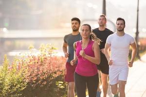 grupp unga människor som joggar i staden foto