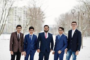 grupp av fem indisk affärsman i kostym poserade utomhus i vinterdag i Europa. foto