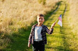 liten pojke med USA flagga utomhus. amerika firar. foto