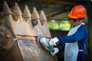 slipskiva elektrisk på stålkonstruktion i fabrik gnistor från slipskiva. grovbearbetning och polering av metaller, gnistor vid metallbearbetning. foto