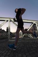 man joggar över bron i staden foto
