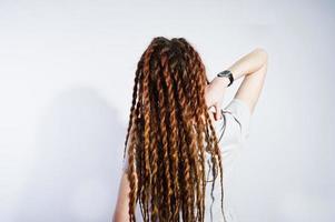 studio skjuta baksidan av flicka i grå klänning med dreads på vit bakgrund. foto