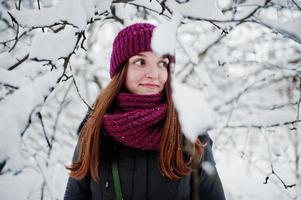 porträtt av flicka på vintern snöig dag nära snötäckta träd. foto