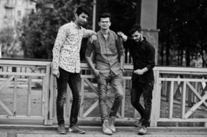 tre indiska killar studenter vänner går på gatan. svartvitt foto. foto