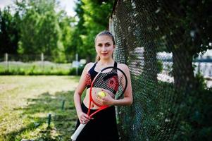 vacker sport kvinna tennisspelare med racket i sportkläder kostym. foto