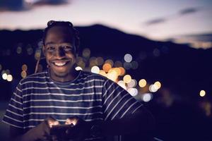 ung afro man på gatan på natten med telefonen foto