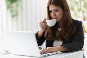 asien kvinna i café med laptop och kaffe, affärsidé