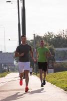 två unga män som joggar genom staden foto