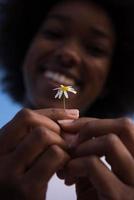 porträtt av afrikansk amerikansk flicka med en blomma i handen foto