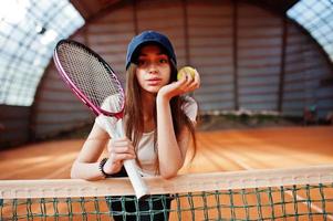 ung sportig tjejspelare med tennisracket på tennisbanan. foto