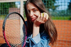 ung sportig tjejspelare med tennisracket på tennisbanan. foto