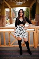 söt latino modell tjej från ecuador bär på svarta toppar och kjol poserade på gatan. foto