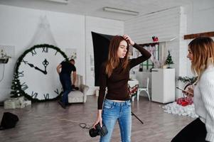 ung fotograf flicka diskuterar med anonther arbetare i studio. foto