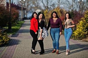 grupp på fyra glada och vackra latino-tjejer från ecuador poserade på gatan. foto