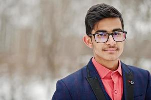 närbild porträtt av elegant indisk student man i kostym, glasögon poserade på vinterdag utomhus. foto