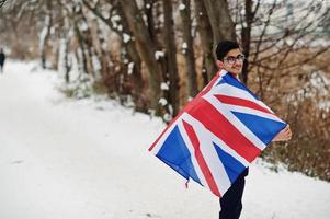 snygg indisk man i kostym med Storbritannien flagga poserade på vinterdag utomhus. foto