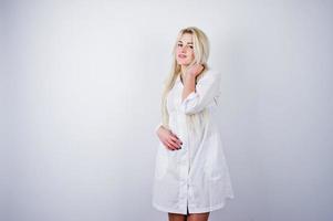 attraktiv blond kvinnlig läkare eller sjuksköterska i labbrock isolerad på vit bakgrund. foto