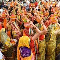 New Delhi, Indien 3 april 2022 - kvinnor med kalash på huvudet under jagannath-templet mangal kalash yatra, indiska hinduistiska hängivna bär jordkrukor som innehåller heligt vatten med en kokosnöt på toppen foto