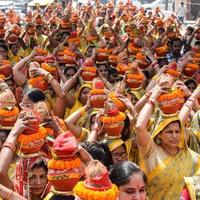 New Delhi, Indien 3 april 2022 - kvinnor med kalash på huvudet under jagannath-templet mangal kalash yatra, indiska hinduistiska hängivna bär jordkrukor som innehåller heligt vatten med en kokosnöt på toppen foto