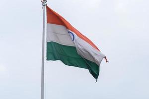 Indien flagga vajar högt på connaught plats med stolthet över blå himmel, Indien flagga vajar, indiska flaggan på självständighetsdagen och republikens dag i Indien, tilt up shot, viftande indiska flaggan, har ghar tiranga foto