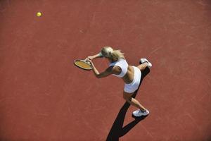 ung kvinna spela tennis foto