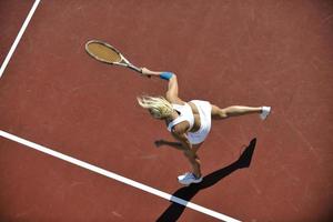 ung kvinna spela tennis utomhus foto