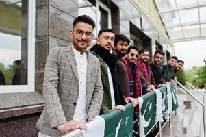 grupp av pakistanska man bär traditionella kläder salwar kameez eller kurta med pakistanska flaggor. foto