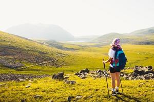 kaukasisk kvinnlig vandrarställning njut av panorama på kullen på vandringsled utomhus i solig dag på levanis sjövandring i georgien foto