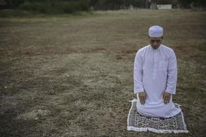 asiatisk islam man bön, ung muslim ber, ramadan festival koncept foto