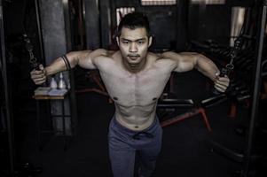 porträtt av asiatisk man stor muskel på gymmet, thailändska människor, träning för bra hälsa, kroppsviktsträning, fitness på gymkonceptet foto